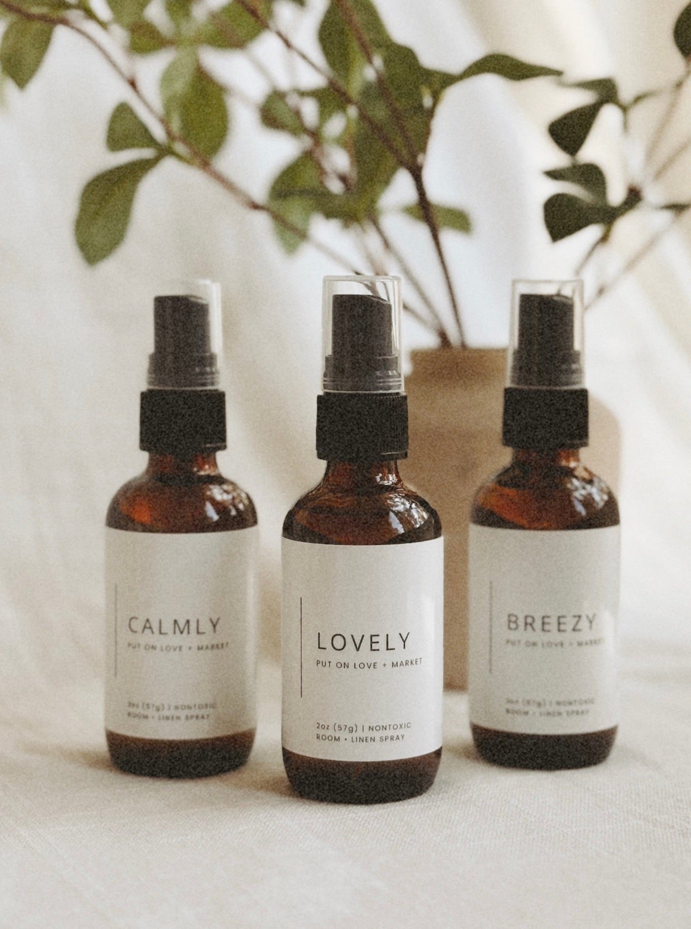 Three room sprays with different labels on them starting from left: CALMLY, LOVELY, BREEZY